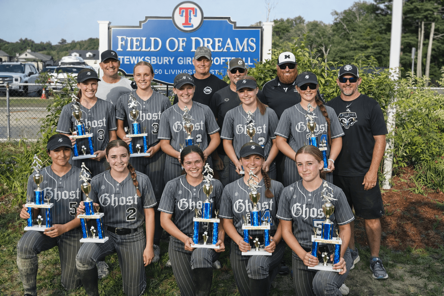 Ghost Premier Softball team celebrating tournament championship victory with trophies
